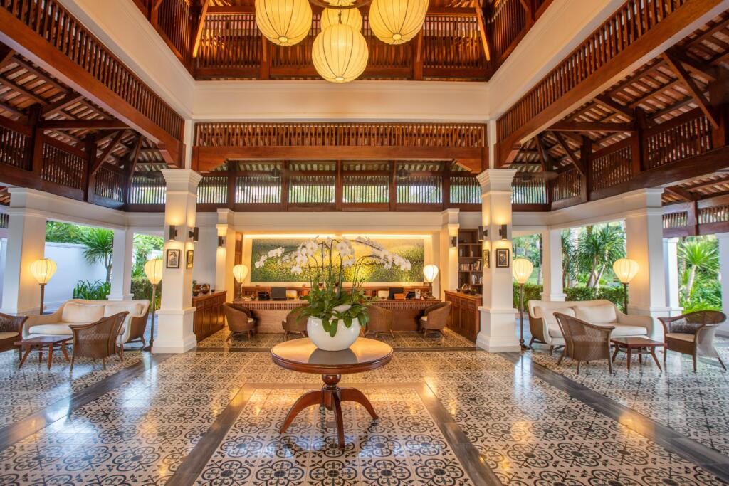 Luxurious hotel lobby featuring elegant wooden architecture, decorative lighting, and a central floral arrangement, reflecting Coyle Hospitality's commitment to enhancing guest experiences in the luxury lodging sector.